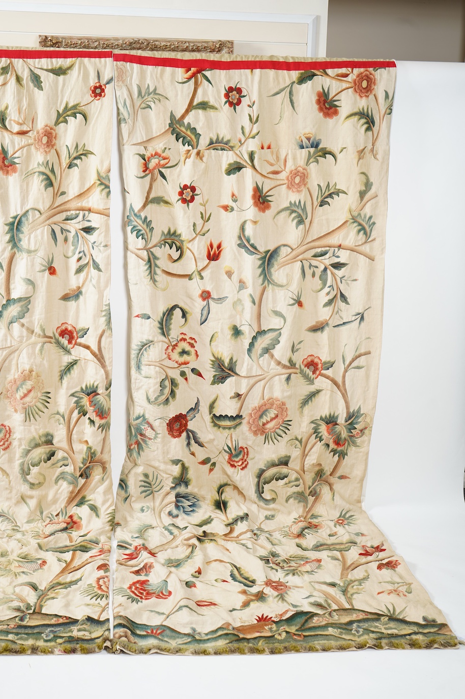 Six 20th century crewel work ‘Tree of Life’ cream linen curtains. Worked at the base in coloured wools depicting a pastoral scene of a shepherd playing a flute amongst sheep, deer, squirrels and flowers with a dog chasin